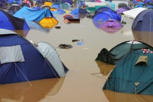 Festival flooding at a UK campsite, with tents part-submerged in muddy surface water after heavy rain