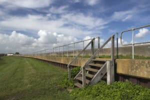 Tidal flood defence wall at Canvey Island, one of the England flood defences protecting low-lying coastal homes.