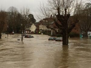 Cars submerged on a flooded UK town street, showing why knowing how to prepare for a flood can reduce damage to homes.