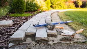 Block paving being laid along a garden path, showing how paving over gardens replaces soil that would otherwise absorb rainfall.