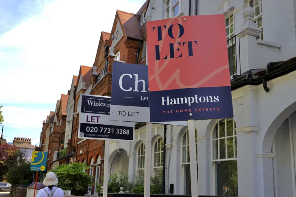Does flood risk affect house prices: estate agent To Let and Let boards outside a row of period London terraced houses.