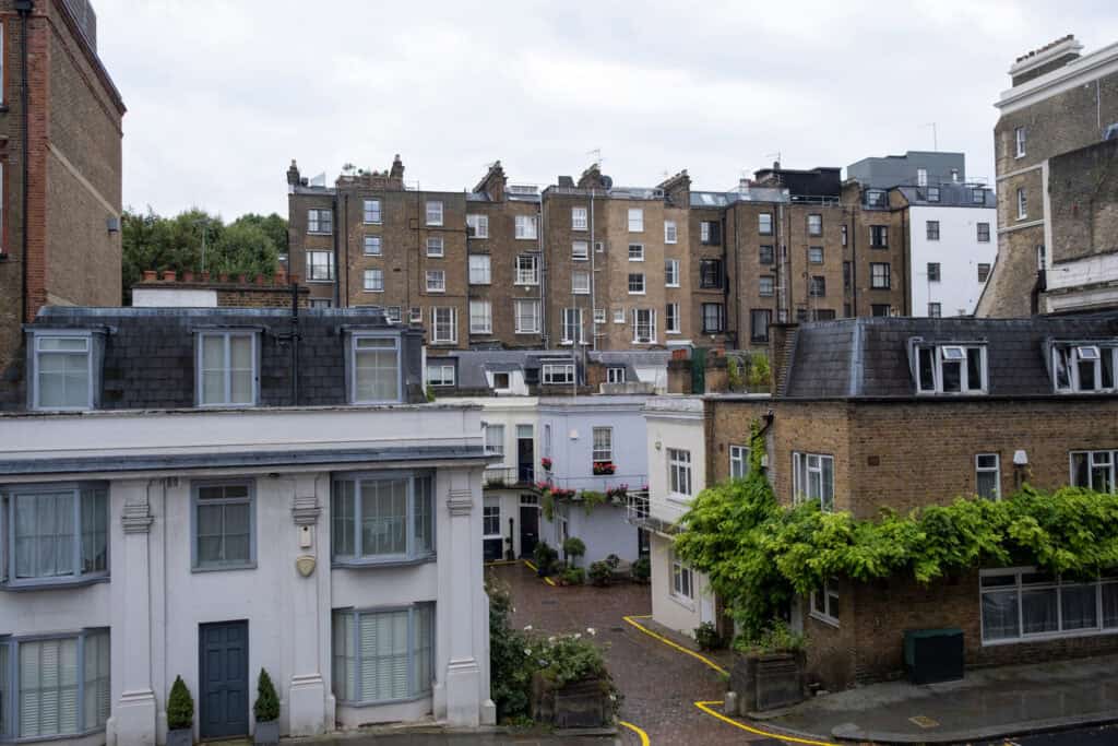 Existing garage court and surrounding residential buildings in Chiswick showing the constrained infill development site context