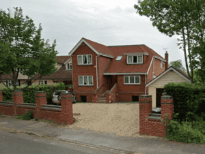 Completed house with floodable void openings in the brick undercroft, raising the finished floor above flood level.