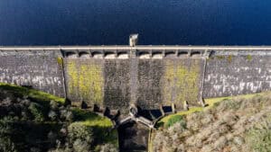 Aerial view of a masonry reservoir dam, a flood defence whose design standard still leaves residual flood risk downstream.
