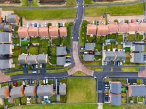 Aerial view of a modern housing estate in England, the kind of development affected by the NPPF 2026 changes to flood risk and drainage policy.