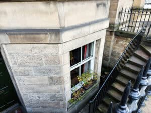 Sunken lightwell and below-ground window on a stone terrace, the entry route a basement conversion flood risk assessment must address.