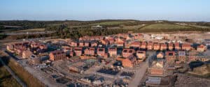 Aerial view of a part-built housing development, illustrating flood risk and drainage in the planning process across a large residential site.