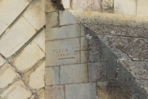 Carved stone flood marker recording the height reached by the 1947 floods on 14 March, above an earlier August 1879 flood mark.
