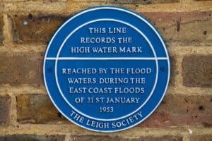 Blue plaque recording the high water mark of the 1953 North Sea flood on a brick wall at Leigh-on-Sea, Essex.