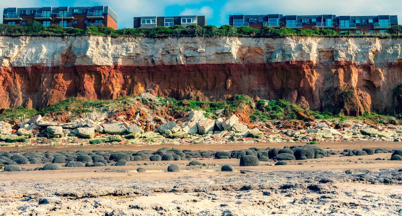 Layered coastal cliff exposing the banded bedrock geology that British Geological Survey mapping records across the country.