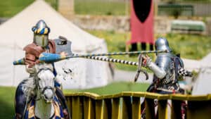 Jousting re-enactment at a castle, the kind of site where medieval drainage had to serve a large working household.