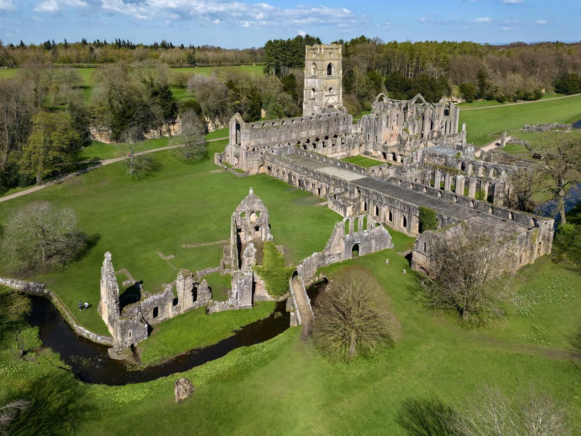 Aerial view of Fountains Abbey with the River Skell canalised through the ruins, a surviving medieval drainage scheme.