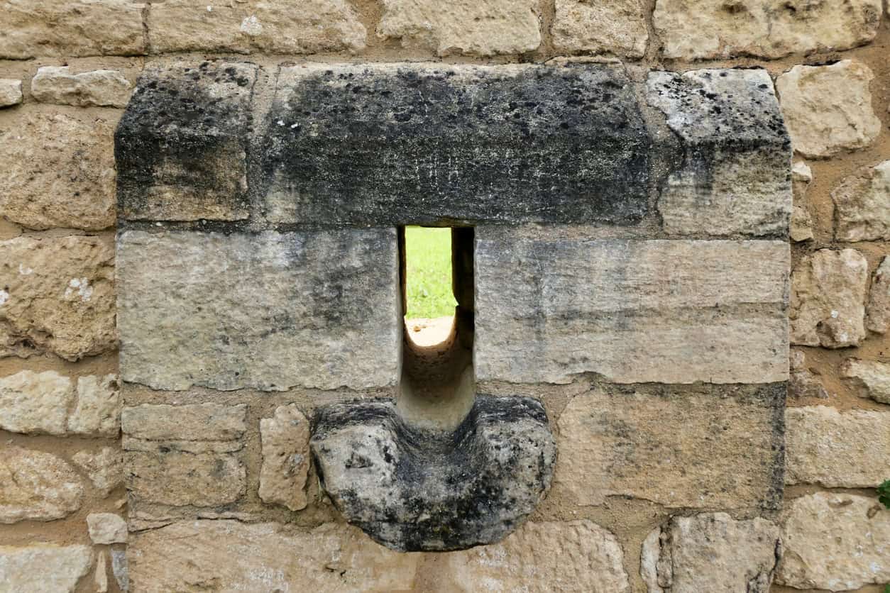 Garderobe outlet through an ashlar wall with a shaped drip stone below it, a surviving detail of medieval drainage.