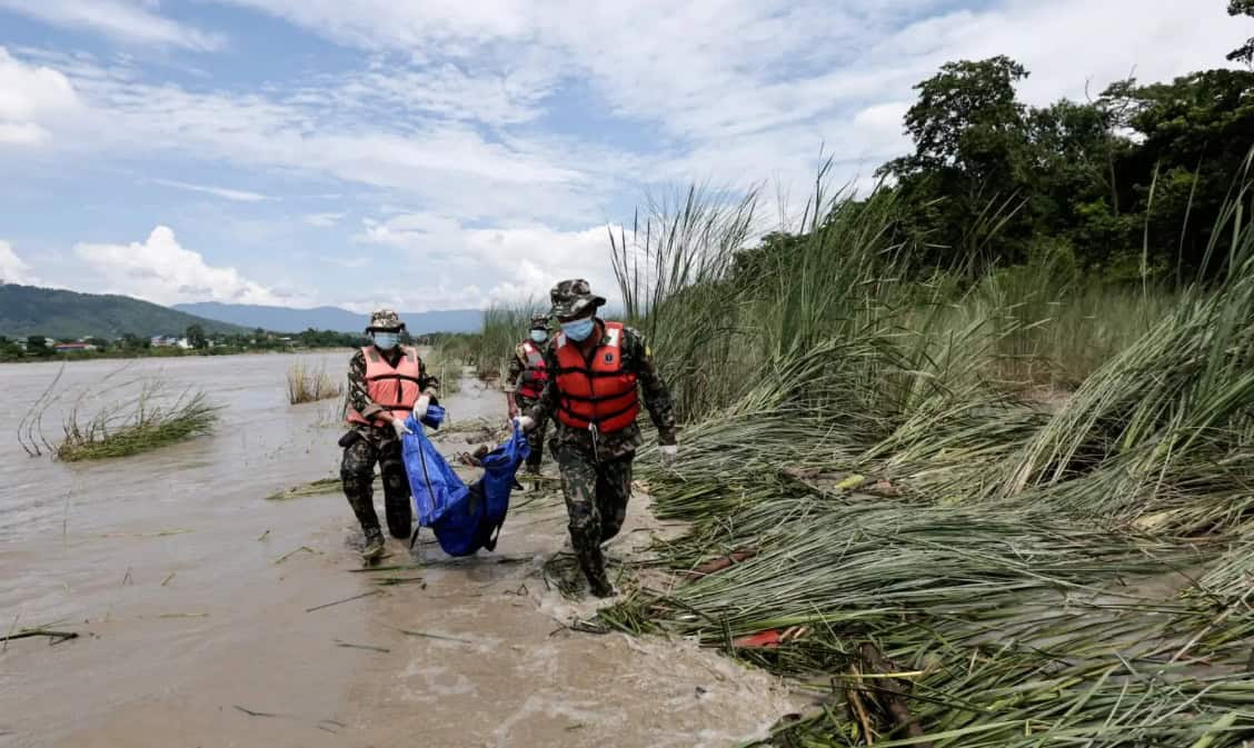 Soldiers carrying a body bag along a lowland riverbank during recovery work after the flood set out in this glacial lake outburst flood explainer.