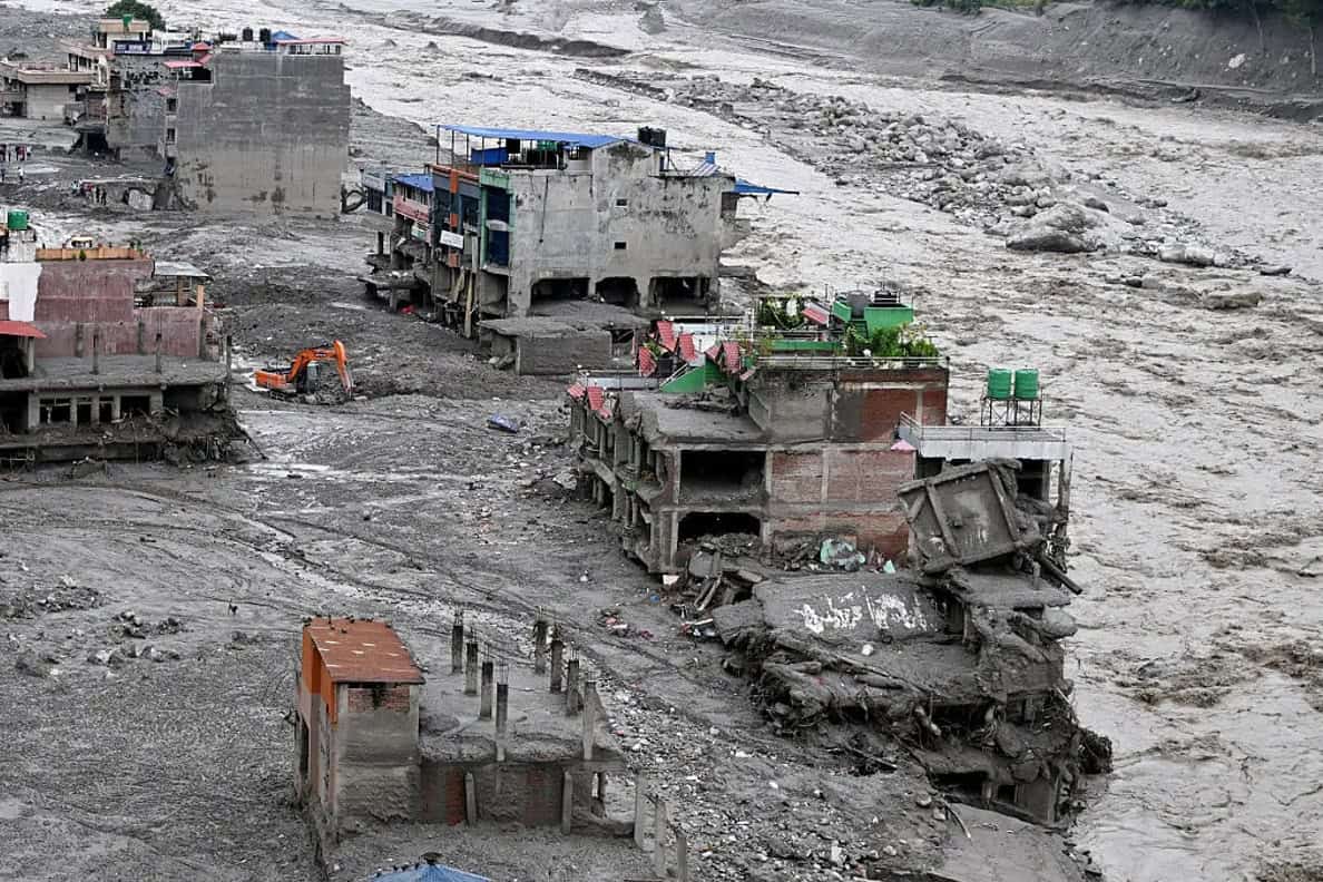 Riverside buildings scoured out and buried in grey sediment after the Nepal flood commonly labelled a glacial lake outburst flood.