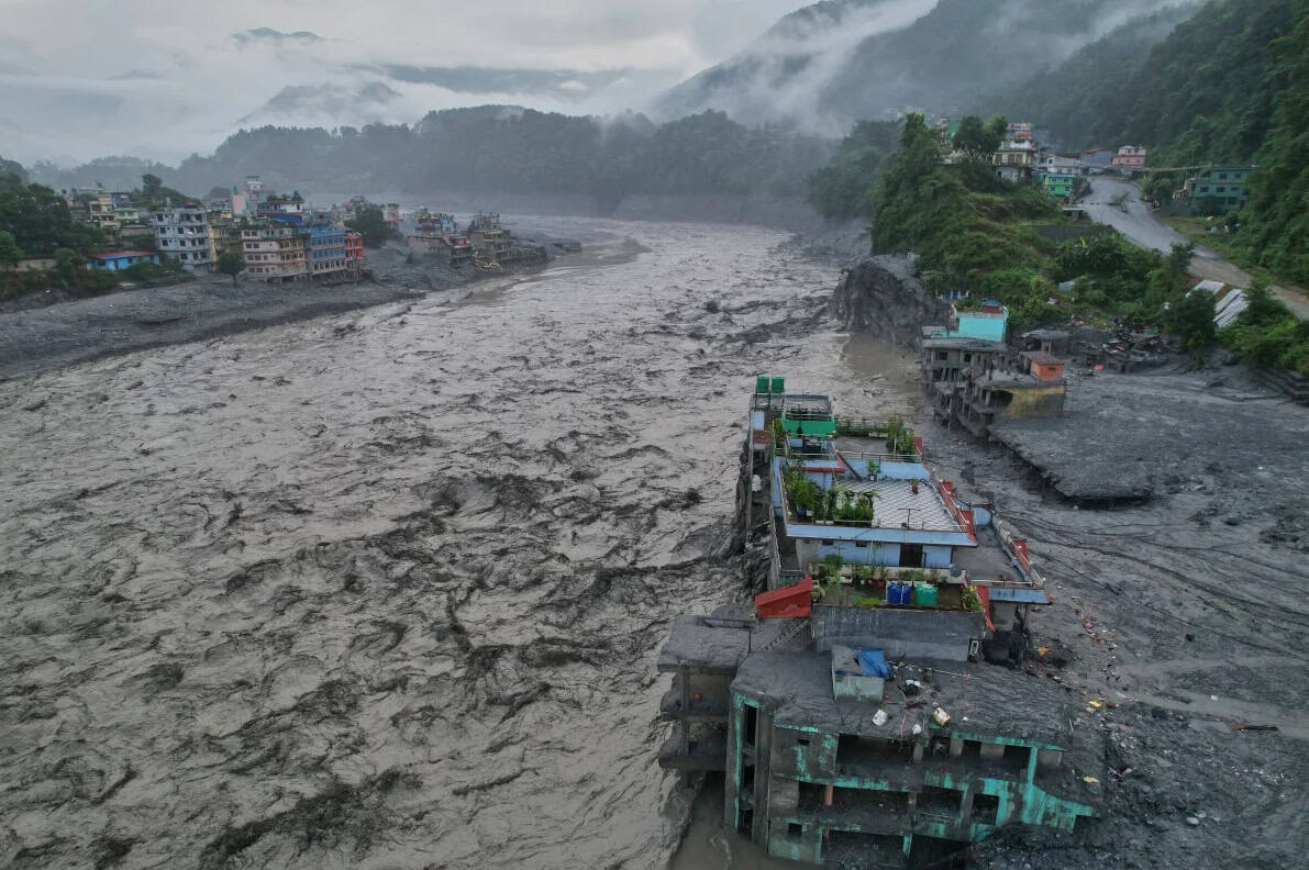 Aerial view of buildings left standing mid-channel after the river widened, in the flood this glacial lake outburst flood article examines.