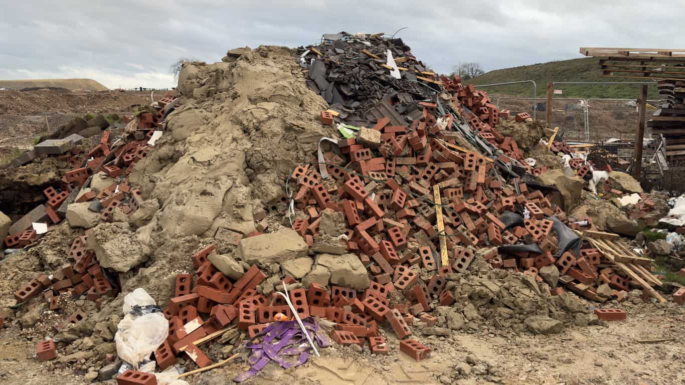 Mixed demolition waste tipped on open ground, the kind of fill used in attempts to raise land out of the floodplain.