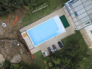 Do you need planning permission for a swimming pool: aerial view of a new garden pool with drainage pipes and an open trench alongside.