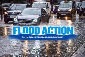 Environment Agency Flood Action graphic for Flood Action Week, with cars and a black cab driving through a flooded city street.