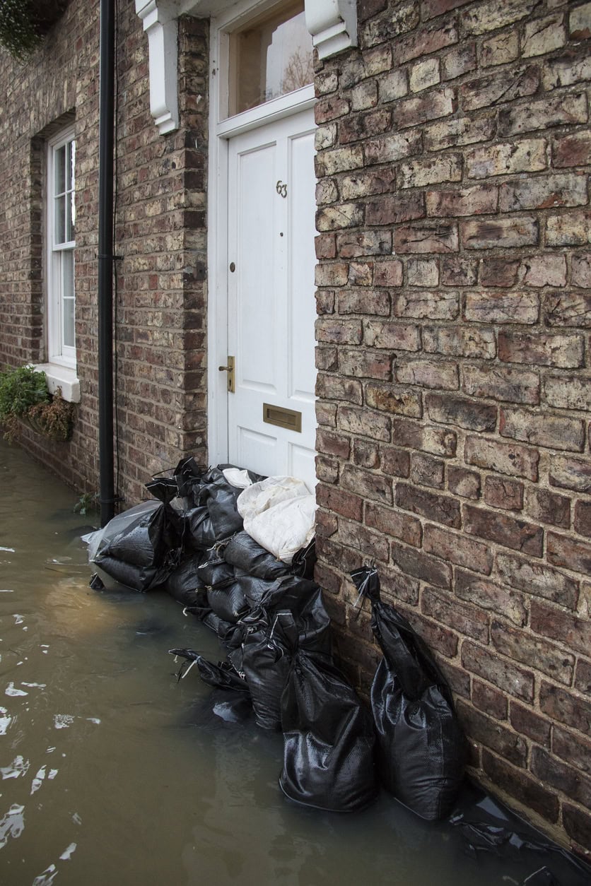 Sandbags piled against a front door in floodwater at Old Malton, a stopgap that purpose-made flood defences for homes replace.