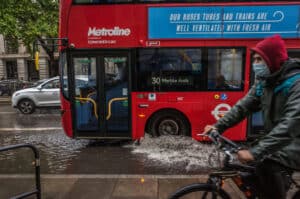 Bus spraying surface water flooding on a London street, the type of event the Flood and Drought Resilience Taskforce covers.