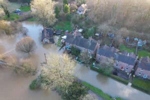 Drone view of the River Severn flooding houses at Ironbridge, where flood defences for homes face a different depth at each house.